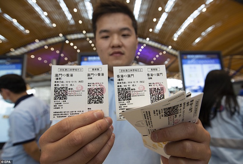 A shuttle bus attendant displays bus tickets at the Hong Kong Port Passenger Clearance Building of the crossing | EPA